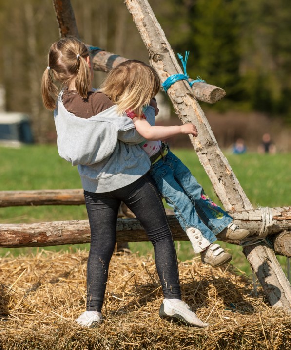 To barn som leker ute ved et tre