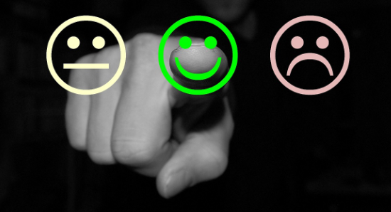 Tre forskjellige smilefjes - En pekefinger som peker på det smilende fjeset