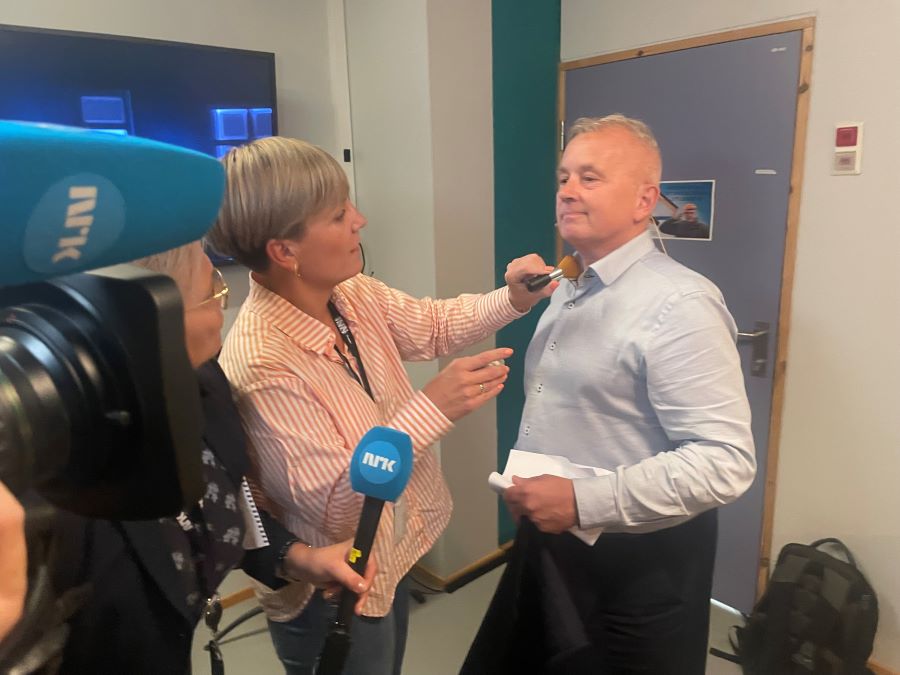 Mann som blir sminket fremfor et kamera
